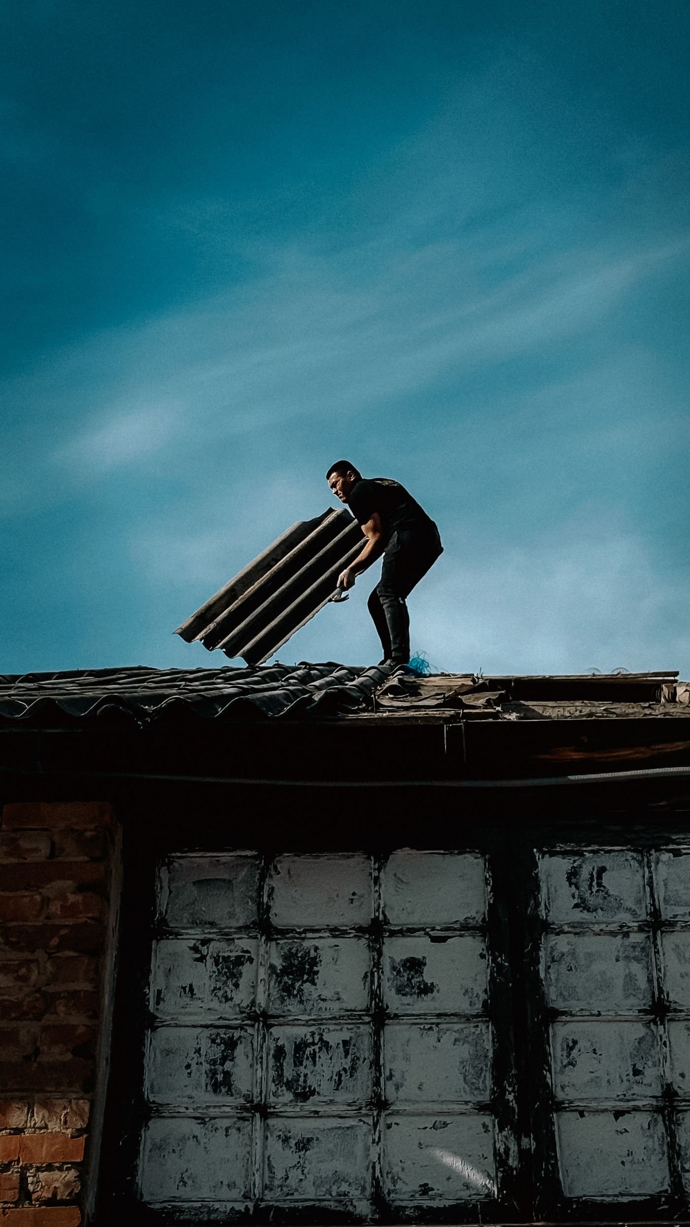 Roofer replacing shingles after storm tree damage, the kind of repair homeowners insurance covers in Texas